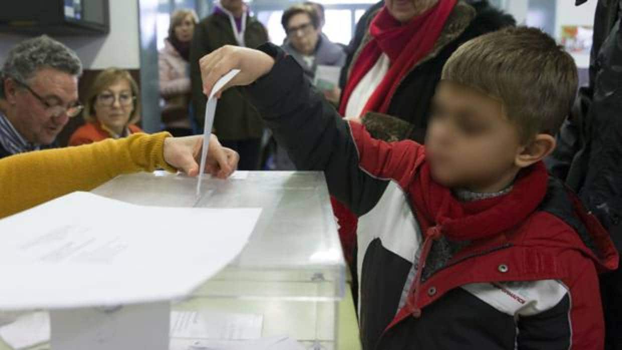 Un niño introduce el sobre en una urna de las elecciones catalanas del 21D