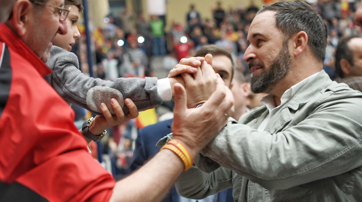 El presidente de Vox, Santiago Abascal, saluda a un niño en un mitin