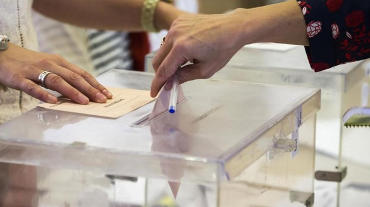 Fotografía de archivo de una mujer depositando su voto en una urna de un colegio electotal