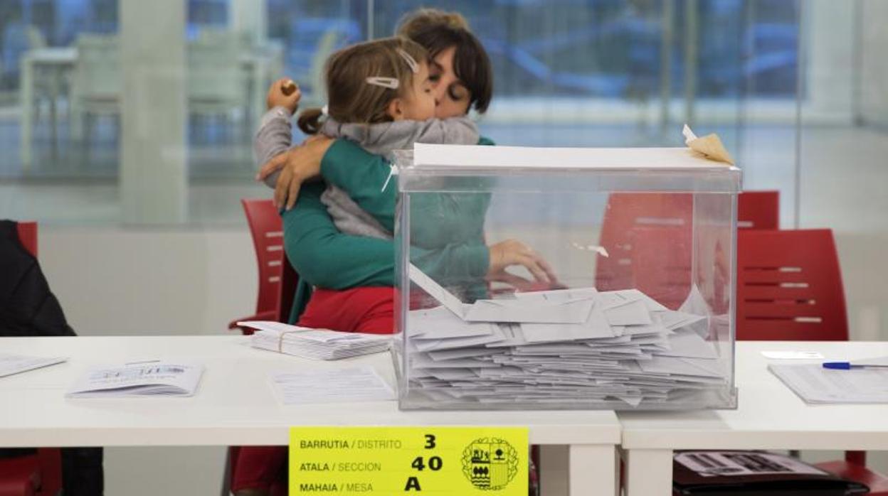 La presidenta de una mesa con su hija en brazos, al término de la jornada electoral en un colegio en el barrio Salburua de Vitoria en 2016