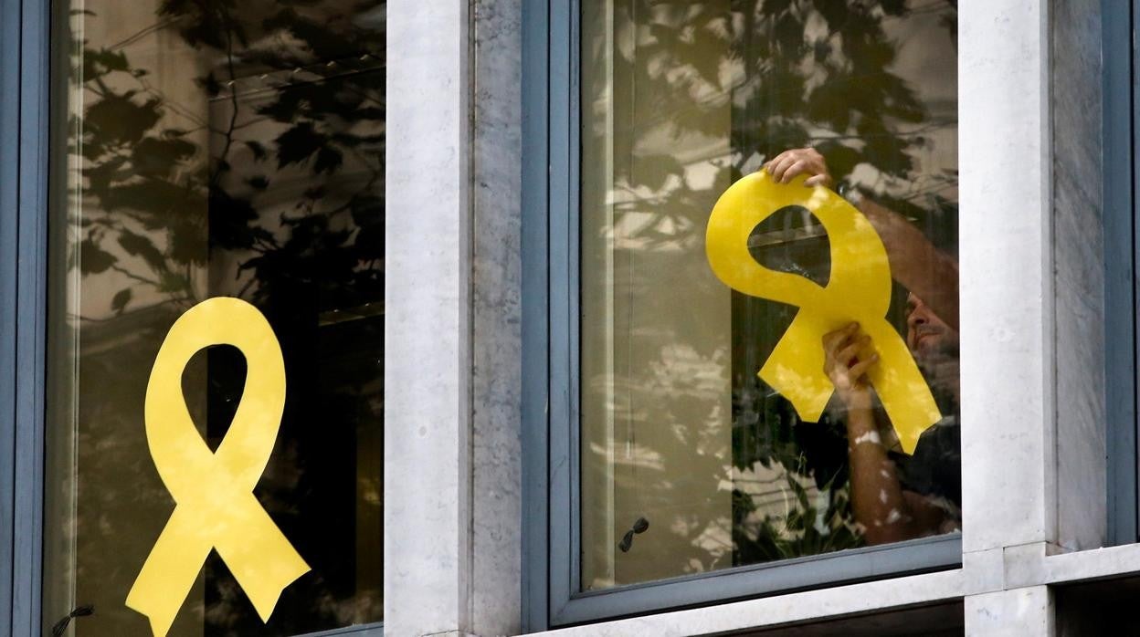 Trabajadores del Departamento de Agricultura de la Generalitat retirando lazos de las ventanas del edificio de la consejería en 2019