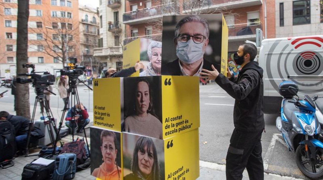 Dos operarios desmontan el material publicitario de la campaña electoral en la sede de ERC en Barcelona