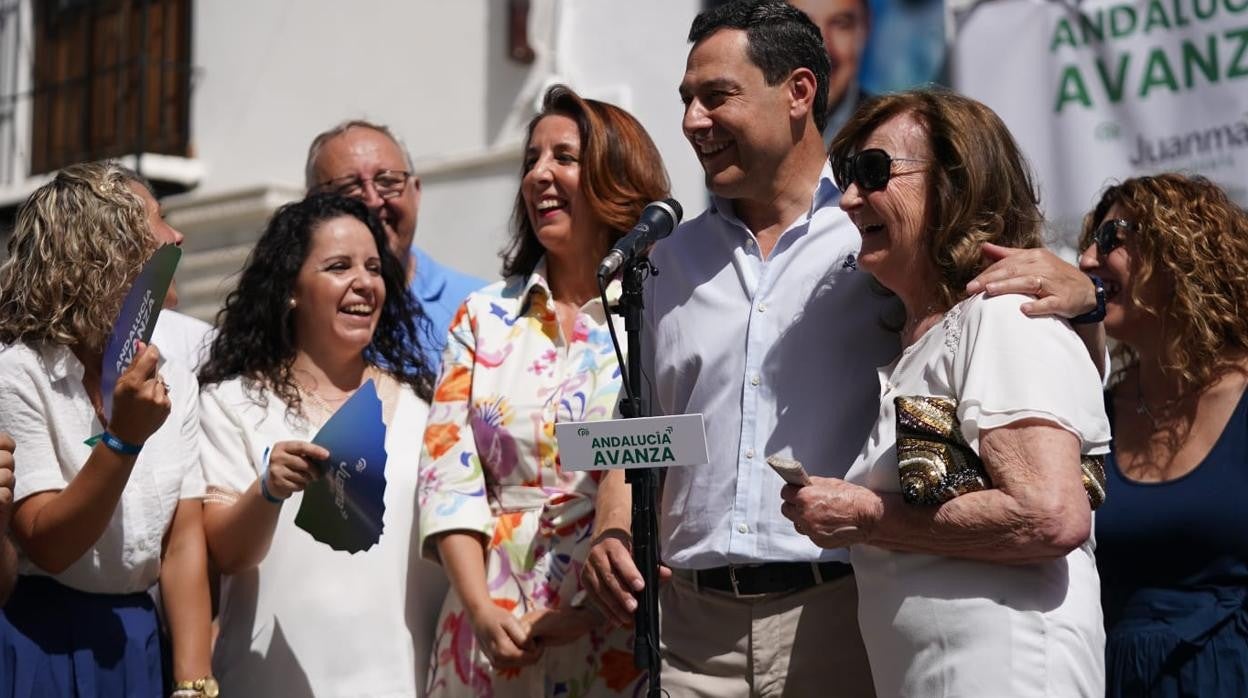 El presidente de la Junta y candidato del PP, Juanma Moreno, durante la visita a su pueblo abrazado a su madre, María Bonilla