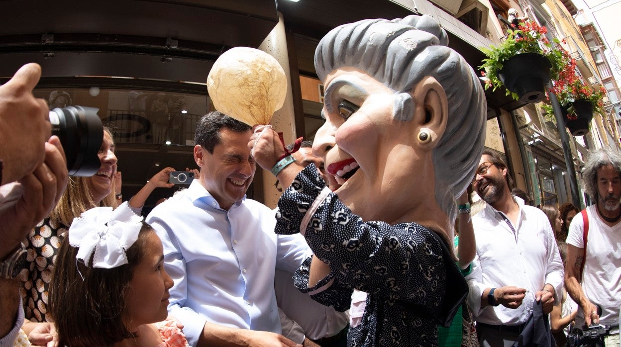 Juanma Moreno junto a uno de los característicos 'cabezudos' de la trasca de Granada