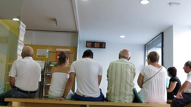 Varias personas en el interior de una oficina de empleo en Alicante