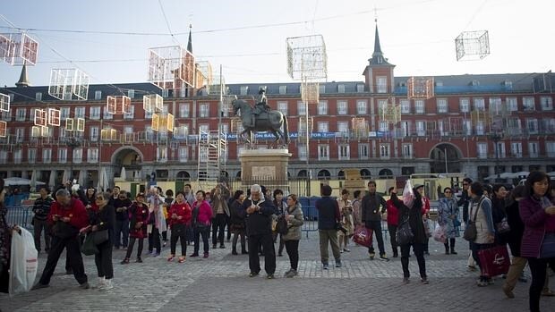La Plaza Mayor, ayer, plagada de turistas que contemplan la instalación del alumbrado y la nueva fachada