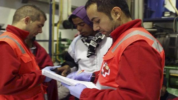 Voluntarios de Cruz Roja atienden a un inmigrante llegado en patera a Torrevieja