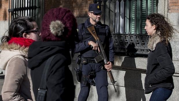 Un policía nacional, con un fusil y chaleco antibalas, este lunes custodiando el Congreso