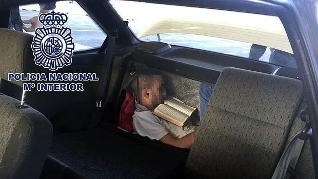 Fotografía facilitada por la Policía Nacional donde se puede ver al inmigrante oculto en el doble fondo del maletero