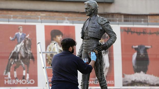 Un operario limpia la estatua de Manolo Montoliu