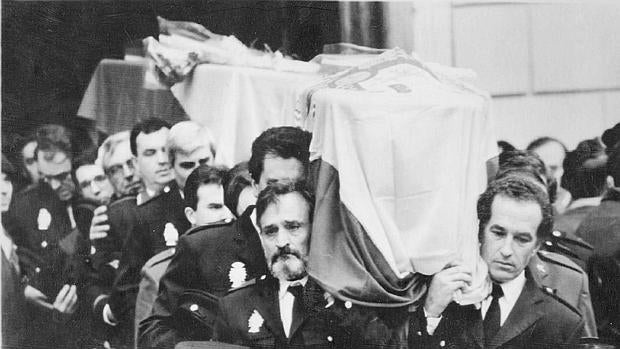 Compañeros de las víctimas sacan los féretros de la iglesia tras el funeral