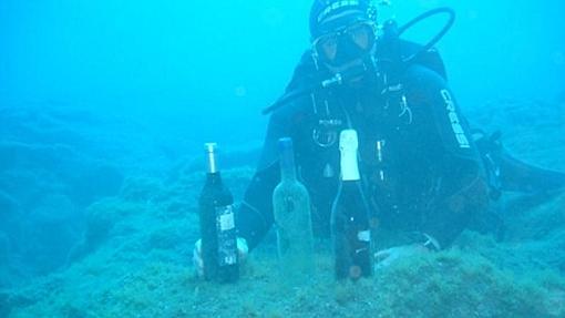 Un buceador muestra varias botellas «submarinas» de la Bodega Castro y Magán, en La Palma