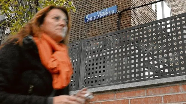 Una mujer pasa por delante de un edificio de la calle Caídos de la División Azul