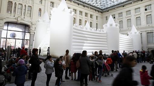 Familias haciendo fila en Cibeles para que sus niños monten en el castillo hinchalbe