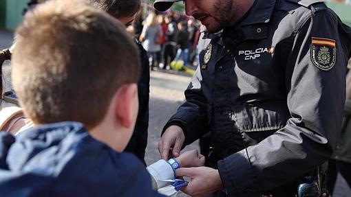 Un agente coloca una pulsera identificativa a un menor en Madrid