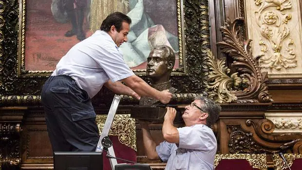 Dos operarios municipales retiran el busto del Rey Juan Carlos el pasado mes de julio