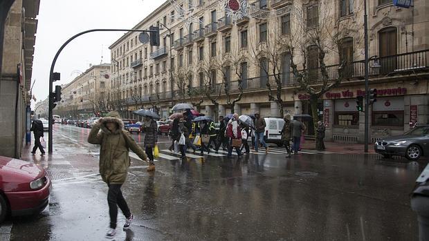 Transeuntes paseando bajo las fuertes lluvias