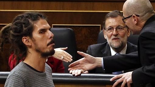 El diputado de Podemos Alberto Rodríguez (izda) pasa junto al presidente del Gobierno en funciones, Mariano Rajoy