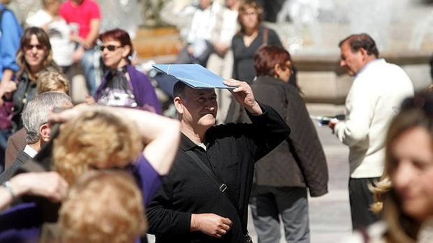 Varias personas se protegen del sol en Valencia