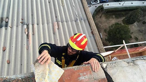 Los bomberos retiran tejas que amenazaban con caer de un edificio del Polígono