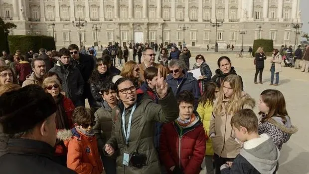 Una guía turística da explicaciones frente al Palacio Real en la Plaza de Oriente de Madrid