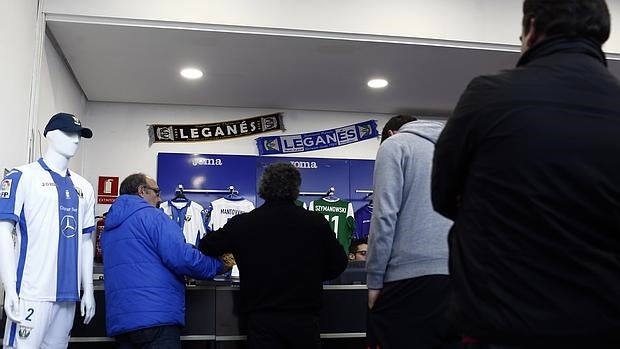 Varios aficionados del Leganés hacen cola en la tienda del club, en el estadio de Butarque