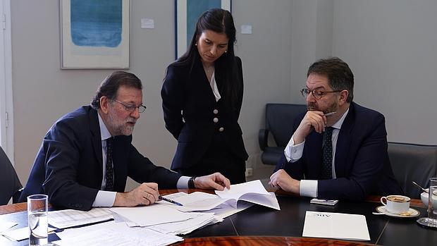 Mariano Rajoy muestra las cifras de la evolución económica de España a Bieito Rubido, director de ABC, y a Montserrat Lluis, subdirectora, al final de la entrevista