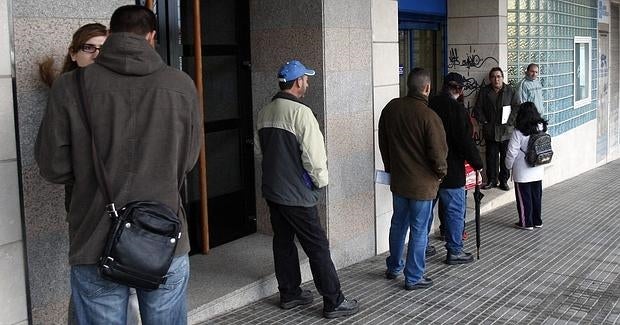 Varias personas aguardan turno a las puertas de una Oficina de Empleo en Santiago