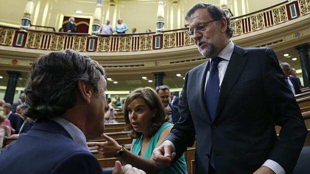 Mariano Rajoy, Soraya Sáenz de Santamaría y, de espaldas, Rafael Hernando, en el Pleno del Congreso