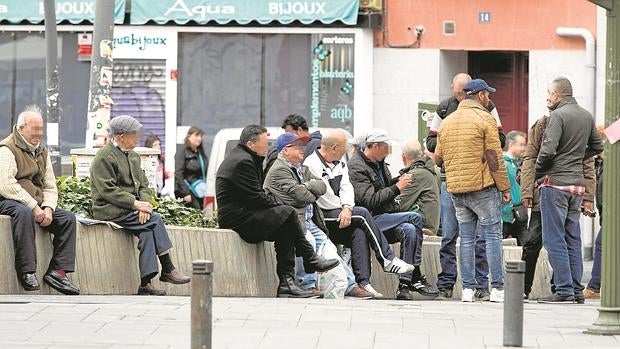 Los jubilados sentados en el muro de Tirso de Molina donde acuden a adquirir la mercancía