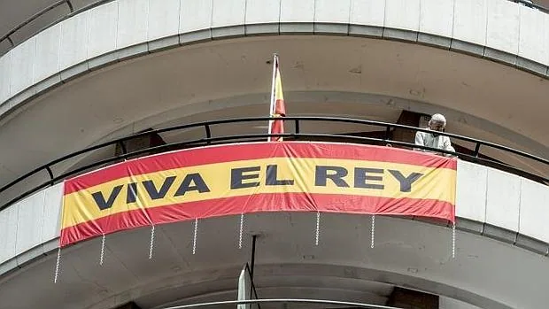 El Marqués de Cáceres ajusta la bandera con la leyenda «Viva el Rey» en su balcón