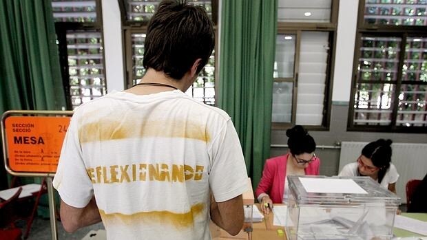Un joven con una camiseta con el lema"Reflexionando" ejerce su derecho al voto