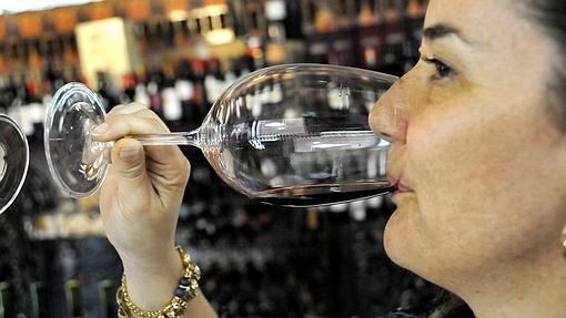 Una mujer bebe una copa de vino