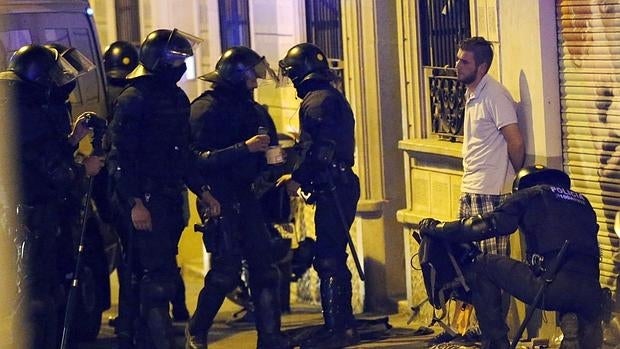 Miembros de los antidisturbios realizan un registro por las calles del barrio barcelonés de Gracia