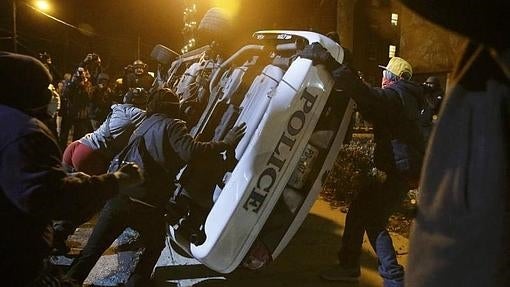 Varias personas vuelcan un coche de policía en Ferguson