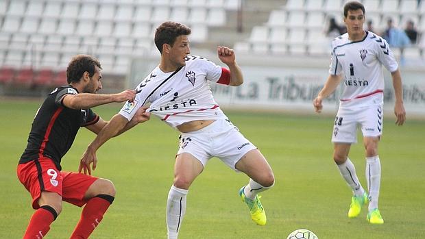 MIguel Núñez, capitán del Albacete, es sujetado por Santamaría, delantero del filial del Bilbao