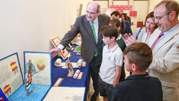 El alumno ganador del concurso, Marco Fernández, explica al consejero su propuesta