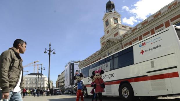 Un autobús de Cruz Roja atiende a los donantes en la Puerta del Sol, frente a la sede del Gobierno autonómico