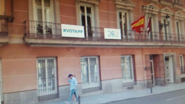 Dos carteles animaban a votar al Partido Popular, colgados esta mañana desde dos balcones del primer piso del Edificio de Grupos