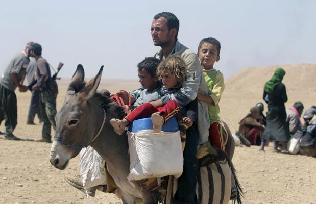 Refugiados sirios huyen por la frontera entre Siria e Irak