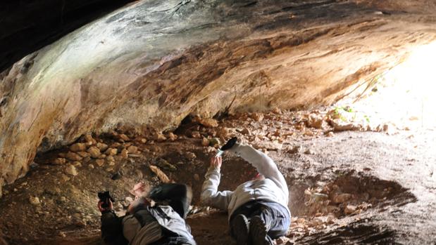 Investigadores analizando restos pictóricos en la Cueva de la Fuente del Trucho (Huesca)