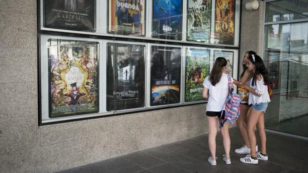 Varias niñas miran la cartelera en un cine de Orense