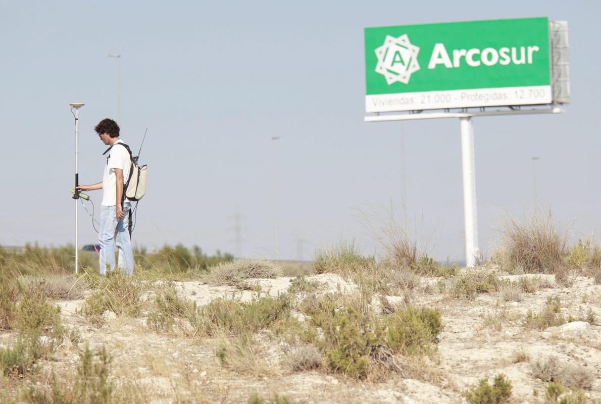 Un topógrafo, trabajando a pie de campo en terrenos de Arcosur, la gran zona de expansión urbana desarrollada en el último decenio en Zaragoza capital