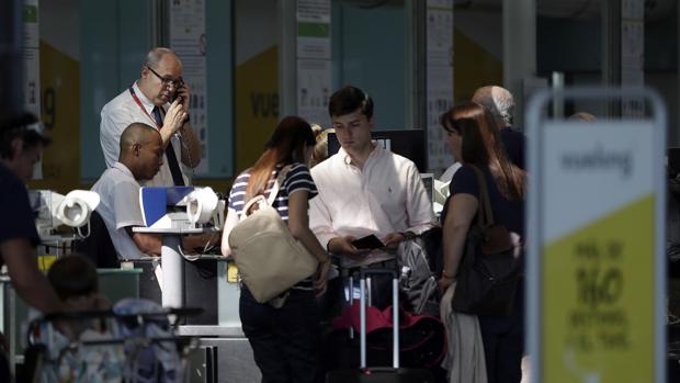 Personal de facturación de Vueling atiende a los viajeros en el aeropuerto de El Prat