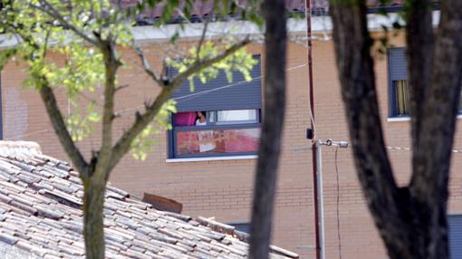 Una inquilina del edificio de la calle Hontanilla mira por una ventana