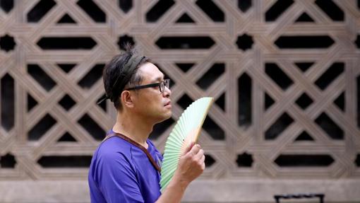 Un turista se abanica por la calle