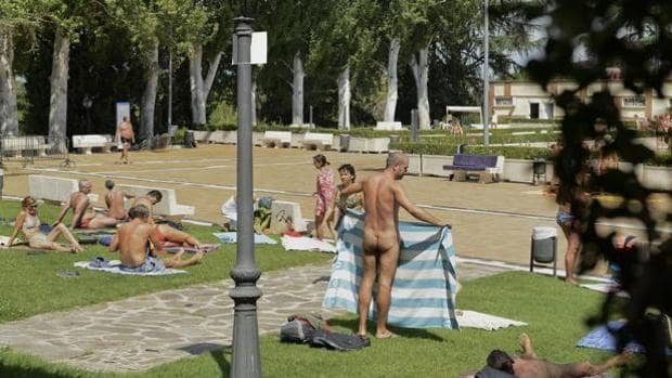 Varias personas desnudas en una piscina municipal