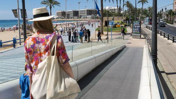 Una turista llega a la playa del Postiguet, en Alicante