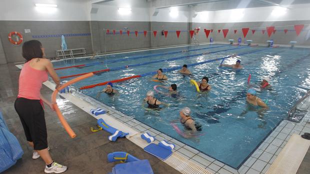 Un grupo de mujeres sigue unas instrucciones de una monitora en una actividad en la piscina