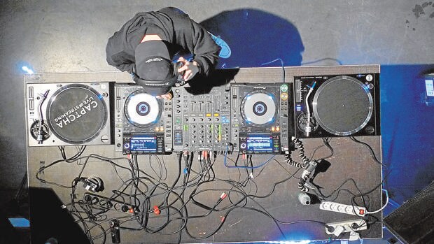 Un DJ selecciona y mezcla música en su equipo